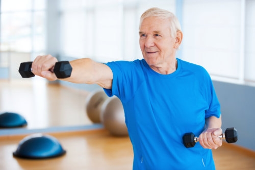 elderly man using dumbbells